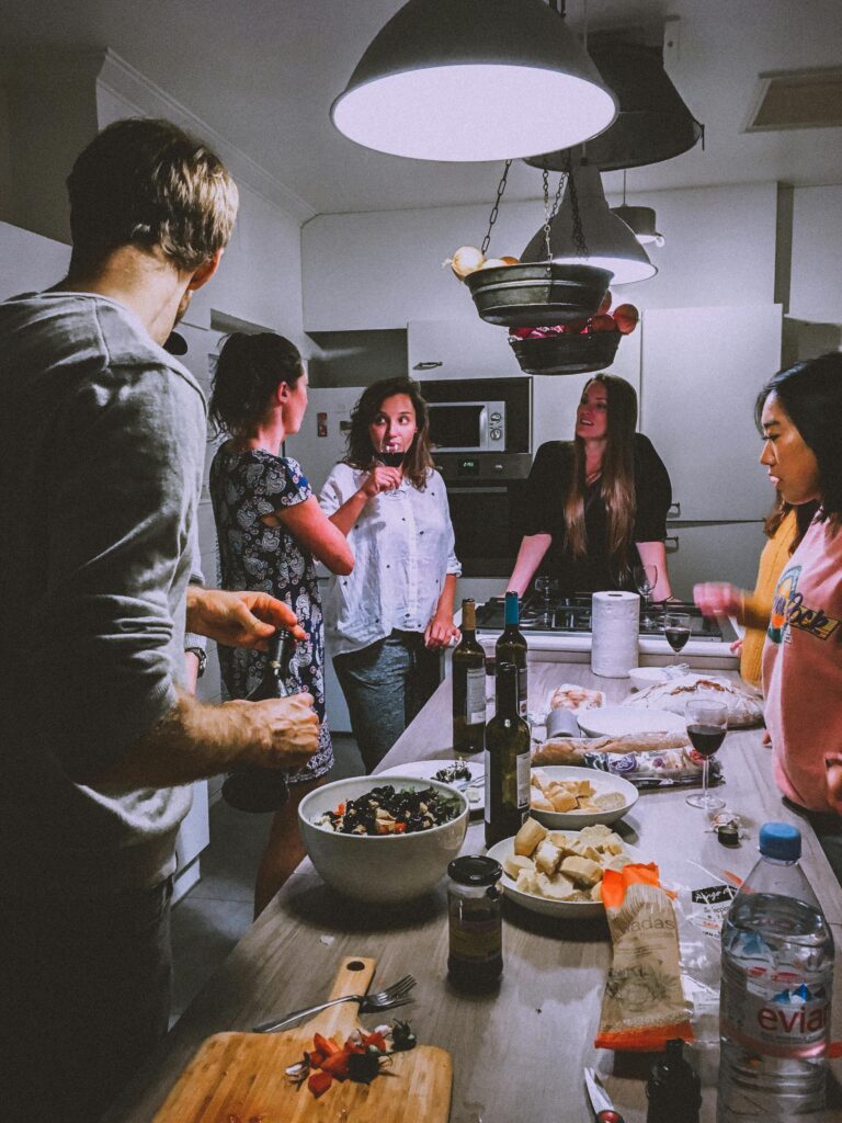 pexels-photo-1655329-1655329 A group of adults enjoying a casual dinner party in a cozy, modern kitchen setting.